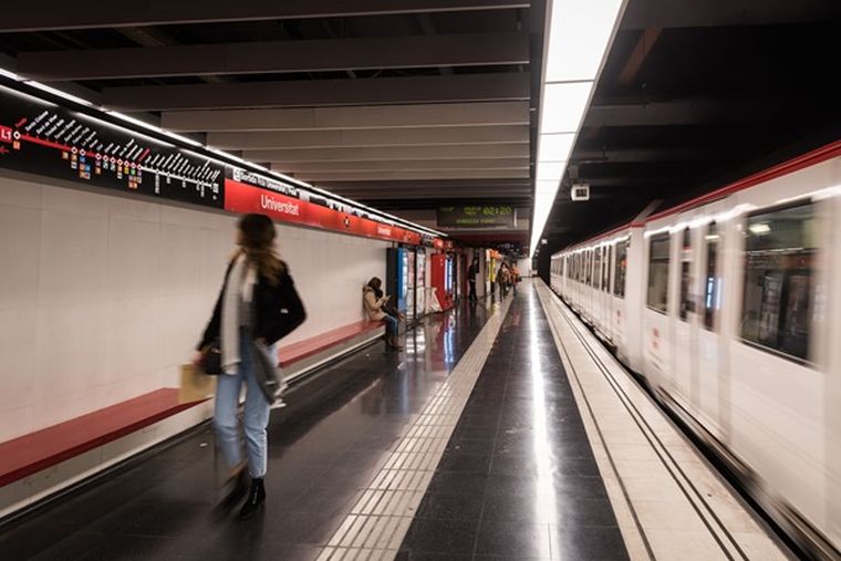 chica en andén del metro , parada de transporte universitat de barcelona 